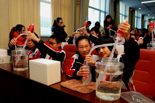 8初一科学实验课上学生探究虹吸现象.JPG