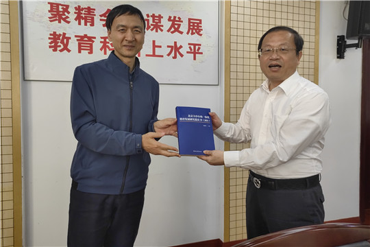 3我院考察组代表向上海教科院院长桑标赠送冯洪荣院长主编的《北京大中小幼一体化德育发展研究蓝皮书》.jpg